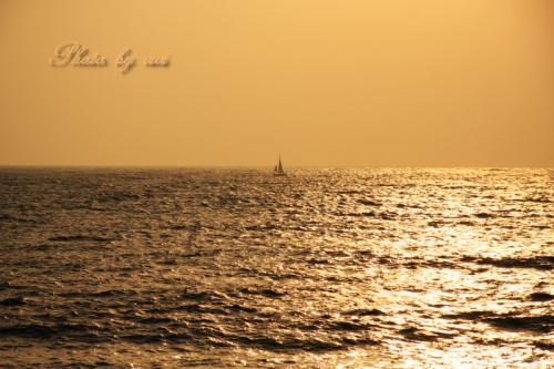 夕焼けの海に漂うヨット